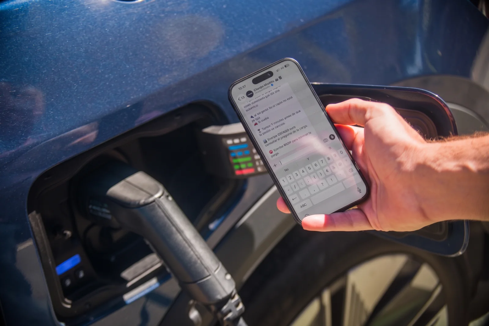 Persona usando el móvil junto al conector de recarga